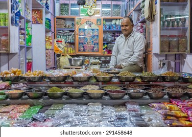 JODHPUR, INDIA - 10 FEBRUARY 2015: Candy Shop Owner Sits While Waiting For Customers With Large Variety Of Mouth-fresheners And Sweets On Display.