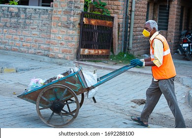 Jodhpur, Rajashtbn, India. 30 March 2020: Indian Man Wearing Mask Pulling Hand Cart Full Of Garbage Cleaning City Roads, New Strain Of Coronavirus, Covid-19 Outbreak, Skilled Worker.