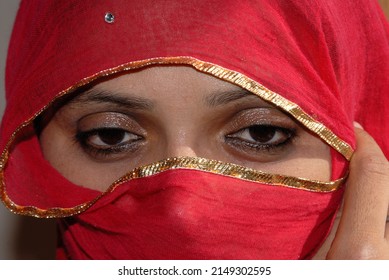Jodhpur Rajasthan India Oct. 09 2006  Portrait of Rajasthani woman in traditional dress red color saree or sari with covered face called a Ghoonghat