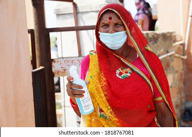 Jodhpur, Rajasthan, India, September 13,2020: Traditional old woman holding sanitizer bottle wearing mask standing outdoor, social worker fight with new strain of coronavirus, second wave of covid-19 
