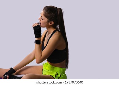 Jogger Eating Energy Bar After Sport Training. Wellbeing And Active Lifestyle Concept. Wondered Caucasian Female Athlete Holding Chocolate Protein Snack. Eating Healthy Sweets For Prolonged Workout.