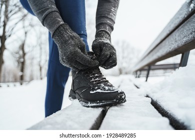 Jogger Man Lacing His Shoes During His Winter Workout In A City Park