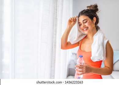 Jogger Run Runner Energy Sweaty Yoga Vitality Wellness Concept. Tired Happy Girl Wiping Sweat With Towel In In Eco Modern Interior Home Studio. Fit Young Woman Drinking Water At The Home.