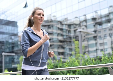 Jogger running around in town - Shutterstock ID 2135277777