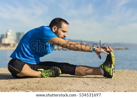 Jogger stretching in the morning on seaside.