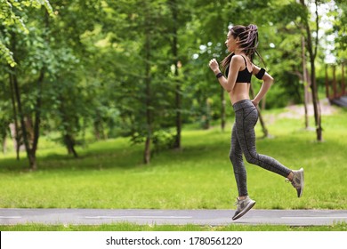 Jogging Concept. Sporty Asian Woman Running On Path In Park, Side View With Copy Space