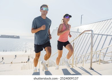 Jogging Couple Climbs Steps by the Waterfront on a Sunny Day in a Vibrant Outdoor Area - Powered by Shutterstock