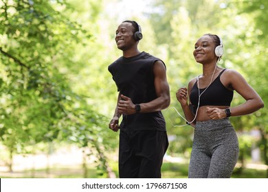 Jogging Couple. Happy Black Guy And Girl Running In Morning Park Together, Feeling Healthy And Motivated, Copy Space
