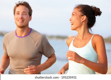 Jogging Fitness Young Mixed Race Couple Running Happy Smiling And Laughing Enjoying Sports Outdoors. Exercising Multicultural People - Young Caucasian Man And Pretty Asian Model