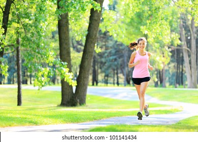 Jogging woman running in park in sunshine on beautiful summer day. Sport fitness model of mixed Asian / Caucasian ethnicity training outdoor for marathon. - Powered by Shutterstock