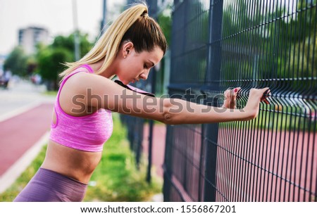 Similar – Young woman stretching legs before training outdoors