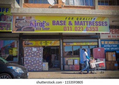 Johannesburg , Gauteng / South Africa -
August 02 2018 : A Man Pushing A Trolley Past A Mattress Shop Store Front Midday Rosettenville Johannesburg