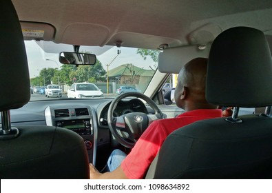 JOHANNESBURG, SOUTH AFRICA -1 NOV 2017- View Of An Uber Driver Seen From The Back Seat In A Car Ride Share In Johannesburg, South Africa.