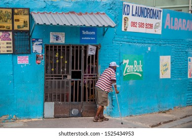 Johannesburg, South Africa , 4 October - 2019: Disabled Man Walking Past Township Shop.