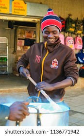 Johannesburg, South Africa, July 12, 2009,   Young African Man Cooking Mielie Pap Maize Porridge On Side Street In Urban Soweto