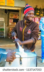 Johannesburg, South Africa, July 12, 2009,   Young African Man Cooking Mielie Pap Maize Porridge On Side Street In Urban Soweto