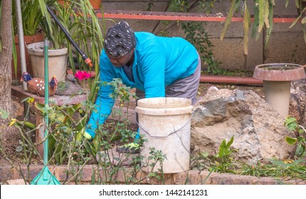 Johannesburg, South Africa - July 2, 2019: An Unidentified Black Male Migrant Worker Does Manual Labor In A Domestic Garden In The City Image In Landscape Format