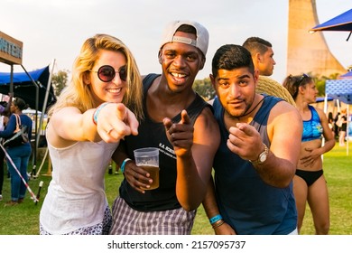 JOHANNESBURG, SOUTH AFRICA - Mar 25, 2022: A Group Of Diverse People Pointing Out The Camera With Their Fingers In The Background Of An Outdoor Party Scene