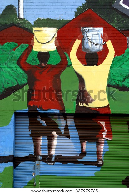 JOHANNESBURG, SOUTH AFRICA - MARCH 15: Colourful, urban mural / graffiti by unknown artist, depicts two African women carrying buckets on their heads. On March 15, 2004 in Johannesburg, South Africa.