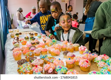 Johannesburg, South Africa - March 24, 2018: African Children Receiving Cupcakes At Soup Kitchen Volunteer Community Outreach Program At Orphanage 