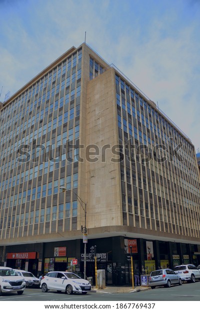Johannesburg, South\
Africa - November 02, 2020: street view of a building and cars\
parked midday Johannesburg\
city