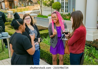 JOHANNESBURG, SOUTH AFRICA - Oct 25, 2021: A group of VIP guests mingling and laughing at an outdoor social event