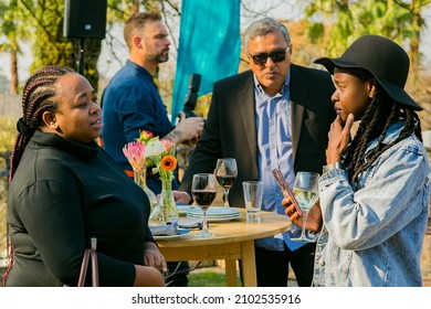 JOHANNESBURG, SOUTH AFRICA - Oct 25, 2021: A group of VIP guests mingling and chatting at outdoor social event