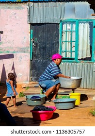 Johannesburg, South Africa, September 11, 2011, African Mother And Child Washing Clothes In Low-income Soweto Neighborhood 