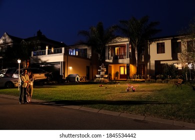 Johannesburg, South Africa - September 11, 2010: A Couple Walking On The Street Of A Upmarket Wealthy Suburban Neighborhood In Gated Community Estate At Night