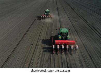 John Deere 6330 tractor, implement, sows corn, sunflowers and beets  with a modern pneumatic precision seed drill. Agricultural aerial view drone photo. Szentmártonkáta, Hungary, April 2, 2021