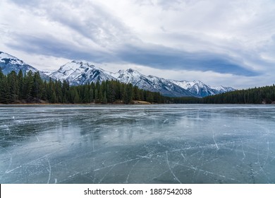 Johnson Lake frozen water surface in winter time. Snow-covered mountain in the background. Tourists here doing ice-skating in this season. Banff National Park, Canadian Rockies, Alberta, Canada. - Powered by Shutterstock