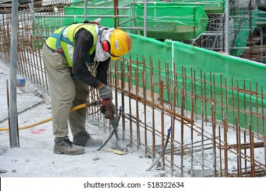 JOHOR, MALAYSIA -AUGUST 29, 2016: Construction workers hacking concrete using electrical powered heavy duty mobile hacker machine at the construction site.   