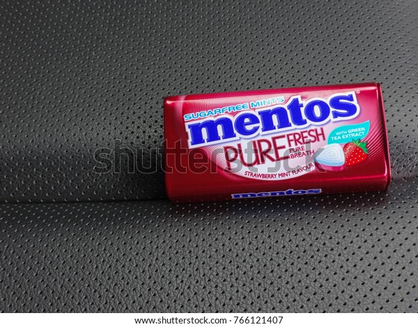 JOHOR, MALAYSIA - November 29\
2017: An opened pack of  Mentos Candy on the car seat. The Mentos\
brand is owned and produced by the Perfetti Van Melle\
corporation.