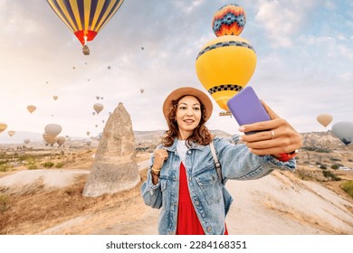 Join the journey of a young woman as she explores Cappadocia, Turkey and shares her experiences through her travel blog. This selfie captures a moment of pure joy. - Powered by Shutterstock