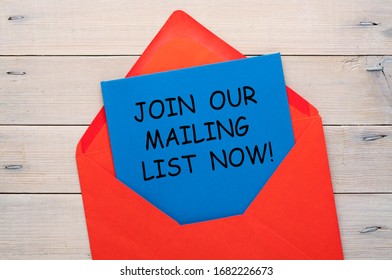 Join Our Mailing List Now Written On Letter At Blue Envelope On Wooden Background. Business Concept.