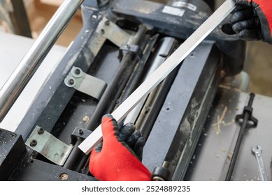 Joiner installing new sharp knives to his machine for cutting and sanding wood. Professional carpenter maintains his tools for quality work - Powered by Shutterstock