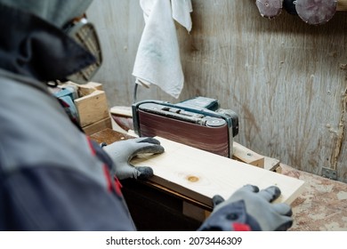 A joiner polishes the board. The process of processing boards in the carpentry workshop. High quality photo
