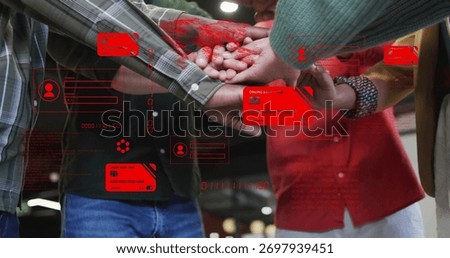 Joining colleagues placing hands in open-plan office, with red credit-card icons and code overlays. Teamwork, collaboration, unity, diversity, innovation, digital interface, modern workspace