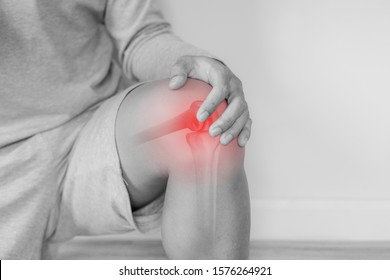 Joint pain, Arthritis and tendon problems. a man touching nee at pain point