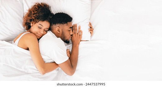 Joint sleep. Happy african-american woman embracing her boyfriend's back, sleeping together in bed, top view - Powered by Shutterstock