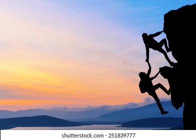 The Joint Work Teamwork Of Two Men Travelers Help Each Other On Top Of A Mountain Climbing Team, A Beautiful Sunset Landscape