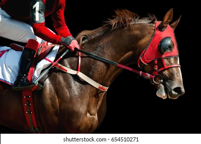 Jokey on a thoroughbred horse in red mask runs isolated on black background