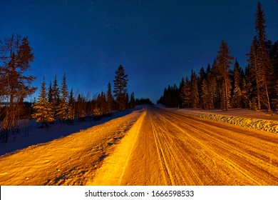 Jokkmokk, Sweden - 03 02 2019: road to Jokkmokk before Polecirkeln-Arctic Circle. northernlights showed short time while roadtrip to the north at mainroad. Stopped to make photos with warninglamps on.