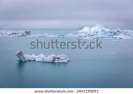 Jokulsarlon glacial lagoon landscape in Iceland, with luminous blue icebergs from retreating glacier drifting towars the Atlantic Ocean.