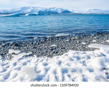 Jokulsarlon iceberg lagoon in winter season with glacier and melting large iceberg under cloudy blue sky in Iceland, in good weather sunshine day