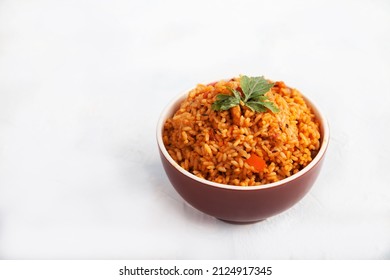 Jollof Rice With Parsley In A Ceramic Cup On A White Background. National Cuisine Of Africa. Copy Spaes.