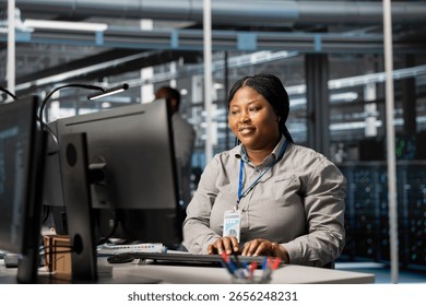 Jolly data center admin analyzing software logs metrics on PC, optimizing storage systems. Joyous server room worker inspecting resource utilization on computer, managing application efficiency