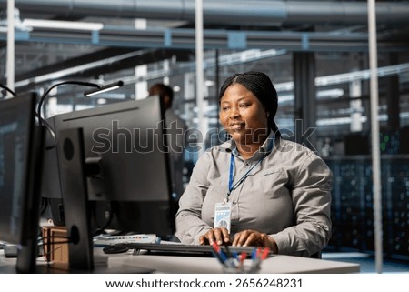 Jolly data center admin analyzing software logs metrics on PC, optimizing storage systems. Joyous server room worker inspecting resource utilization on computer, managing application efficiency