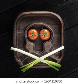 Jolly Roger Skulls And Crossbones Theme Made With Tomatoes, Onion, Spoon And Fork On Wooden Background