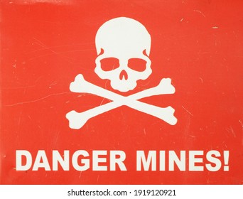 Jolly Roger (white skull-and-crossbones) on a red sign warning of the danger of landmines